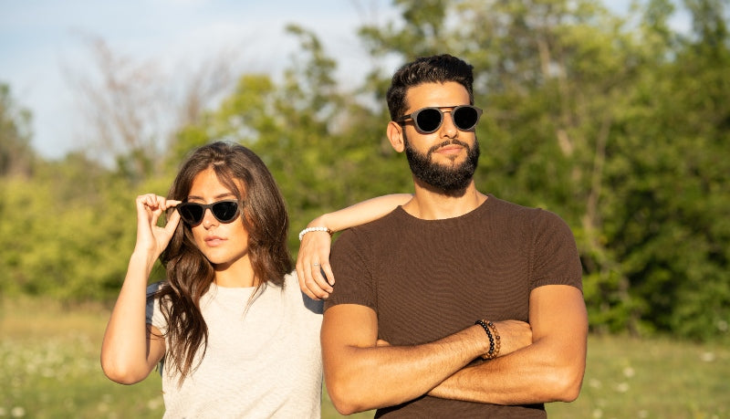 man and woman wearing sunglasses in forest