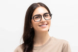 Femme portant des lunettes Haya, modèle aviateur carré noir et verres transparents - vue de face sur fond blanc