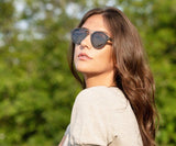 Donna che indossa gli occhiali da sole Kraywoods Ash, Rounded Aviator Wood con lenti polarizzate grigie