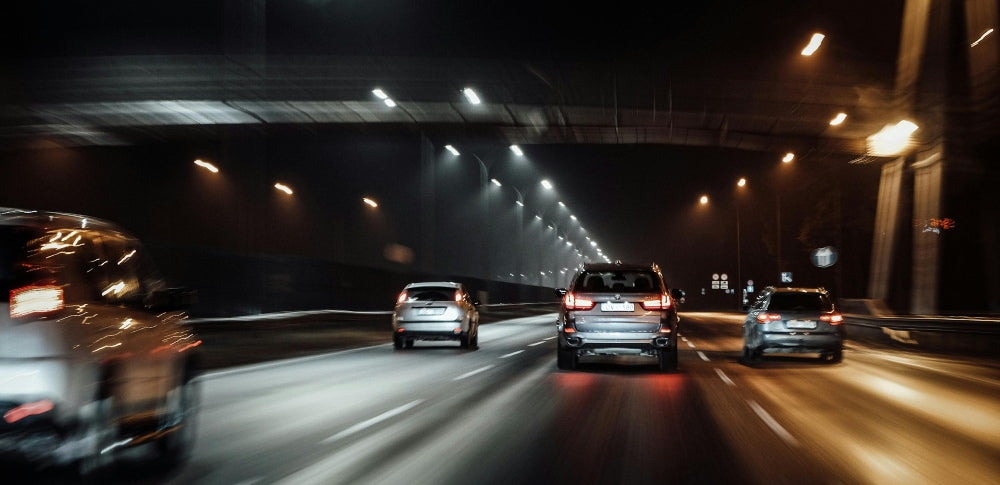 Bilar kör i tunnel på natten