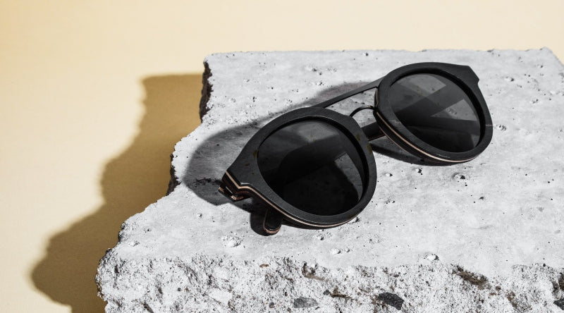 flatlay de lunettes de soleil Ash sur un rocher gris avec un fond rose clair