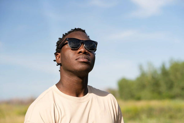 Man with light sensitivty wearing sunglasses while staring at the sky