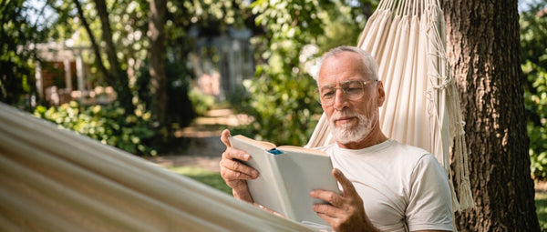 man wearing Kraywoods progressive lens glasses while reading outdoors