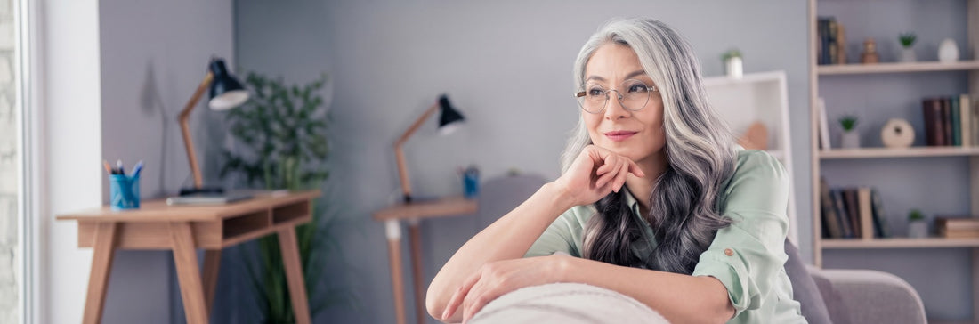 Woman with grey hair wearing round metal glasses