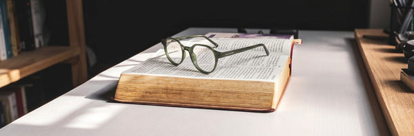 Kraywoods reading glasses placed on a chunky open old book