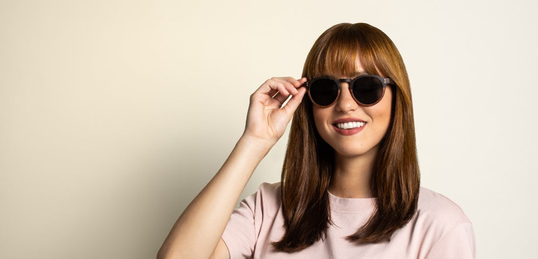Femme au visage oblong portant des lunettes de soleil rondes