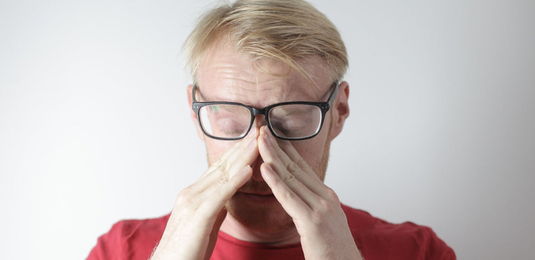 man wearing eyeglasses with an allergic reaction on a white background