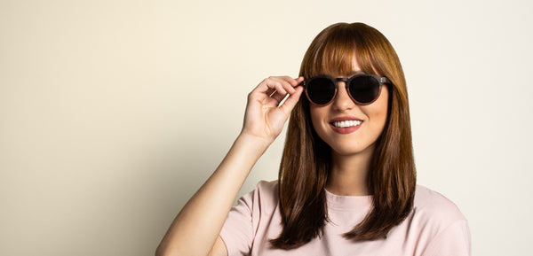 Femme au visage oblong portant des lunettes de soleil rondes