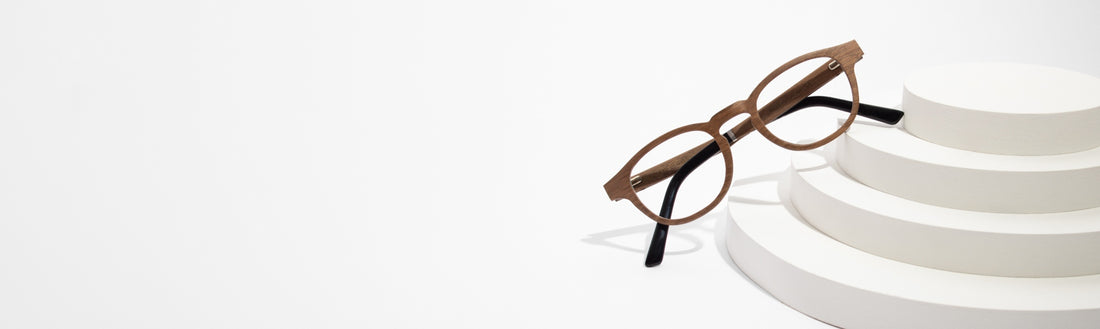 flat-lay image of wooden eyeglasses frames on a white background