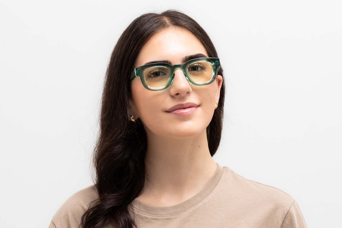 Woman wearing Juno Green, thick rounded square green sunglasses with yellow lens