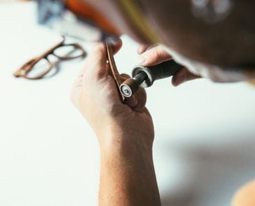 man handcrafting wooden eyeglasses frames