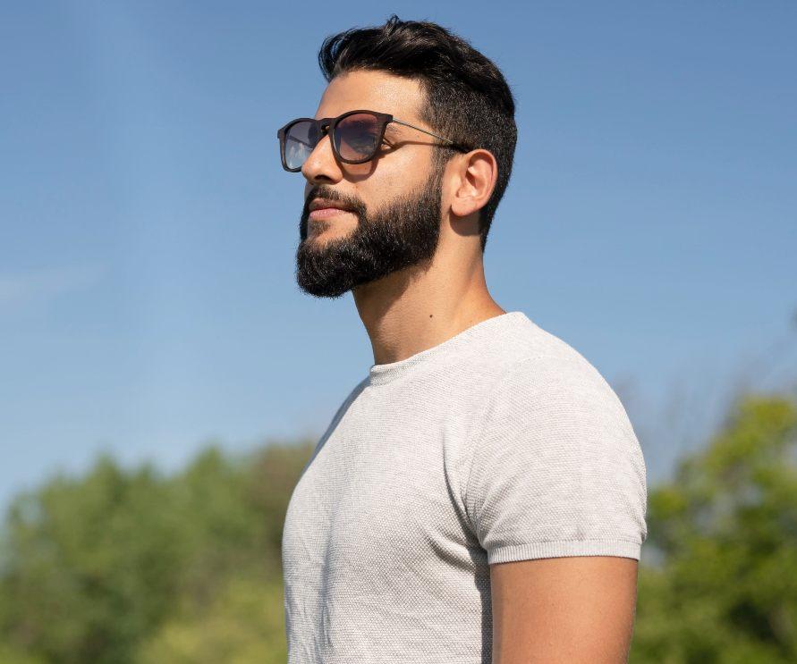 Homme portant des lunettes de soleil Kraywoods Hazel, rétro carrées en bois de noyer avec verres polarisés dégradés, protection UV à 100%