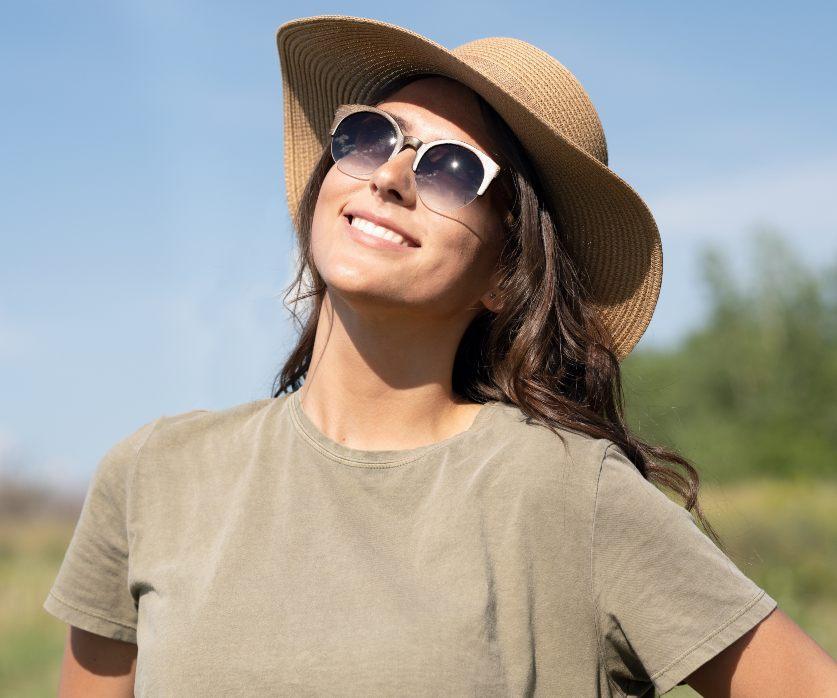 Femme portant des lunettes de soleil rondes rétro en bambou Tom & Cat de Kraywoods avec verres marron dégradé avec protection UV à 100%