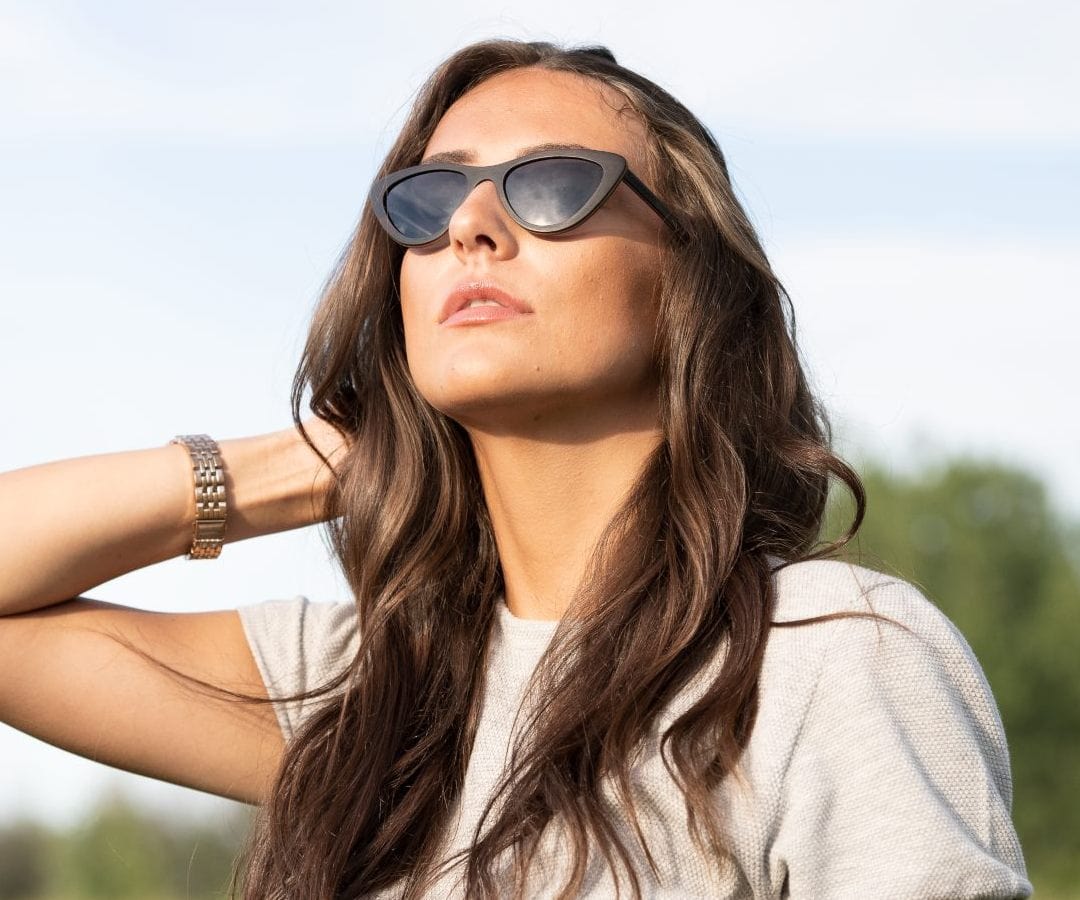 Femme portant Kraywoods Selena, petites lunettes de soleil œil de chat en bois d'ébène avec lentilles polarisées 100% UV