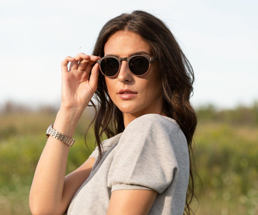 Femme portant Kraywoods Roseland, lunettes de soleil rondes en bois d'ébène et de rose avec protection UV à 100%, verres polarisés