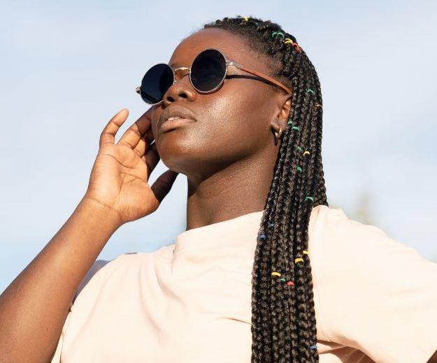 Woman wearing Kraywoods Lennon, John Lennon Sunglasses Featuring Vintage Gold Circle Frame and 100% UV Protection, Polarized Lenses