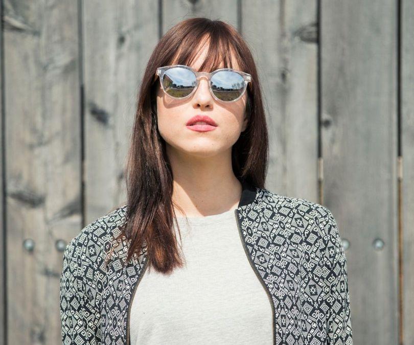 Woman wearing Kraywoods Groove, Round Reflective Sunglasses Featuring Clear Frame and Zebra Wood Arms with 100% UV Protection, Polarized Lenses