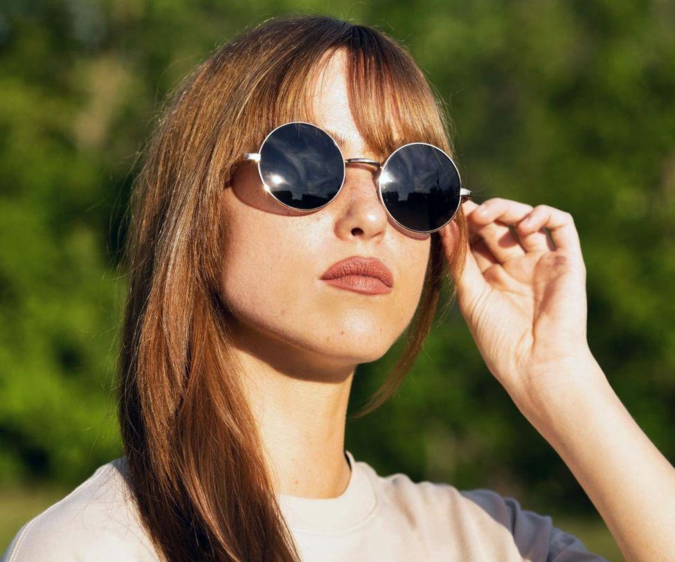 Woman wearing Kraywoods Lennon, John Lennon Sunglasses Featuring Vintage Gold Circle Frame and 100% UV Protection, Polarized Lenses