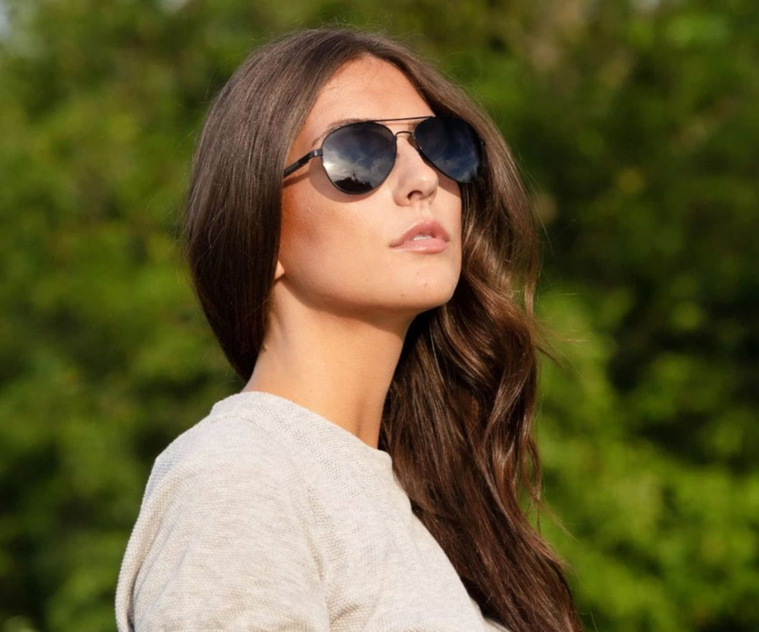 Femme portant des lunettes de soleil aviateur noires Kraywoods Leo avec bras en bois d'ébène avec protection UV à 100%, verres polarisés