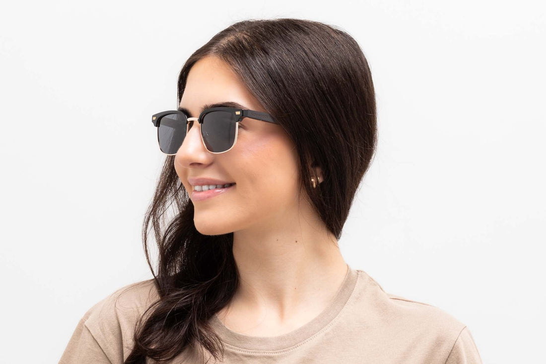 Frau mit Black Jaguar , Browline-Sonnenbrille mit grauen polarisierten Gläsern - Vorderansicht auf weißem Hintergrund