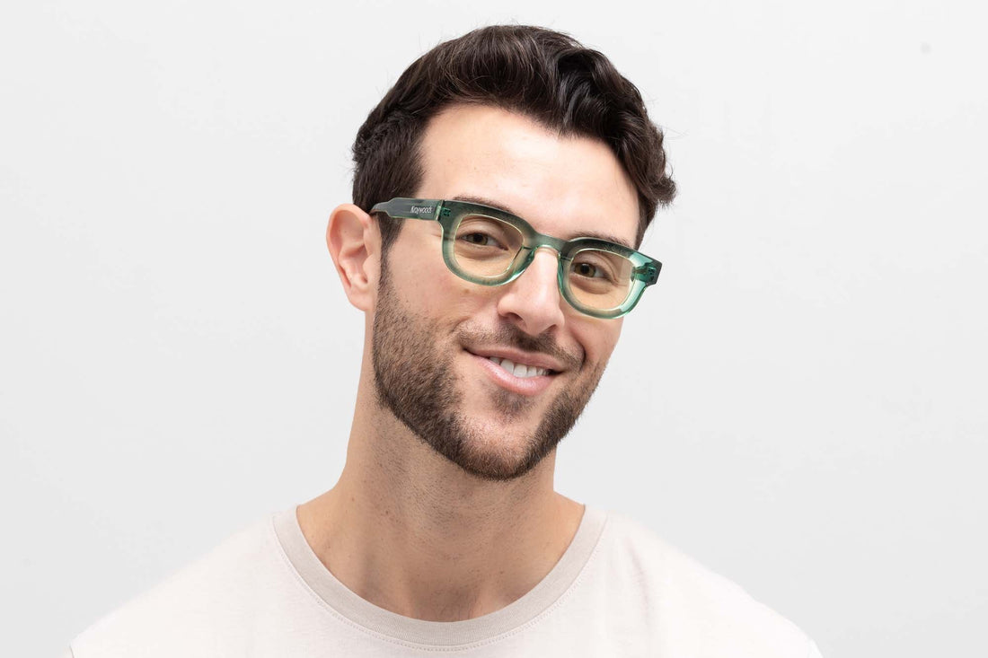 Mann trägt Juno Green, eine dicke, abgerundete, quadratische grüne Sonnenbrille mit gelben Gläsern