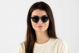 Mujer con gafas de sol redondas azules transparentes