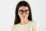 Mujer con gafas de montura negra, redondas y gruesas