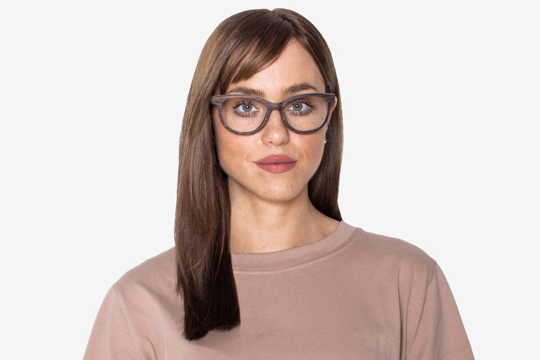 Mujer con gafas de madera de ojo de gato y charm morado