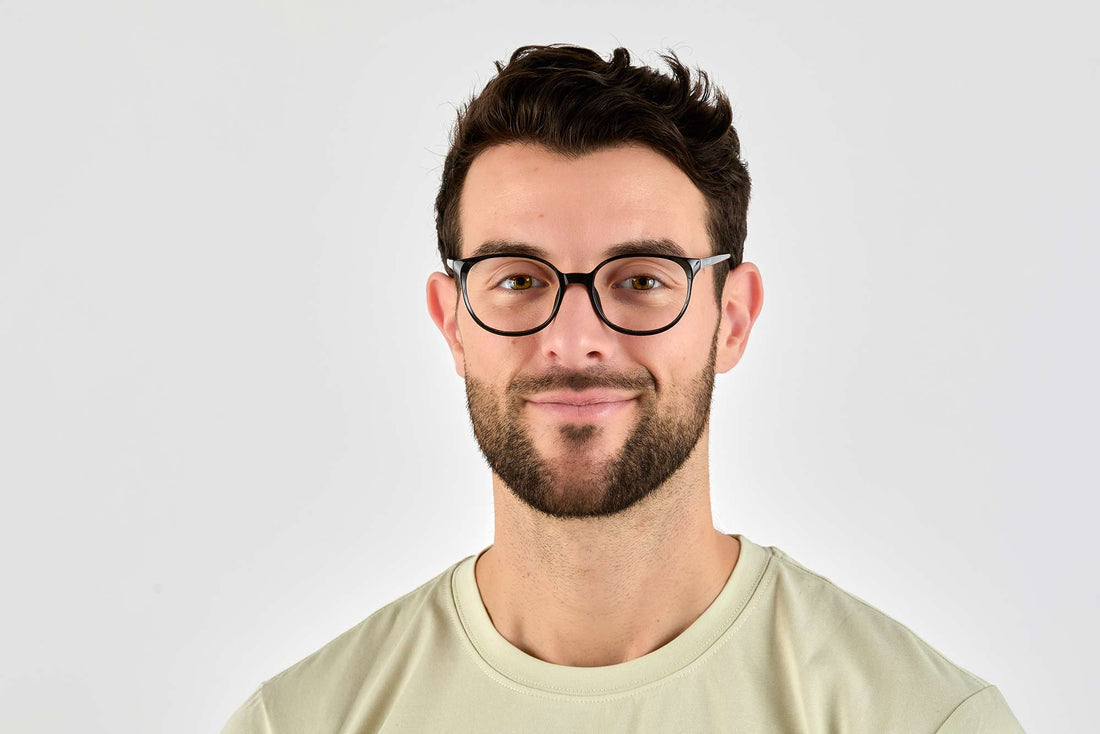 Hombre con gafas de acetato negras, ovaladas y serenas