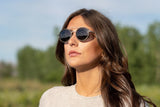 Mujer con gafas de sol Aspen plateadas, redondas y de doble puente