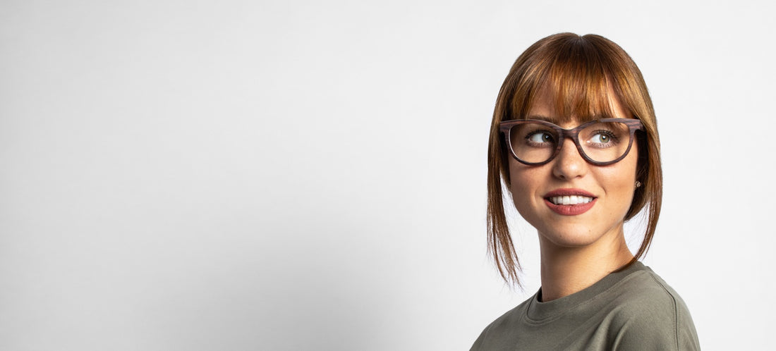 Femme portant des lunettes Charm Purple, monture en bois œil-de-chat, sur fond blanc.