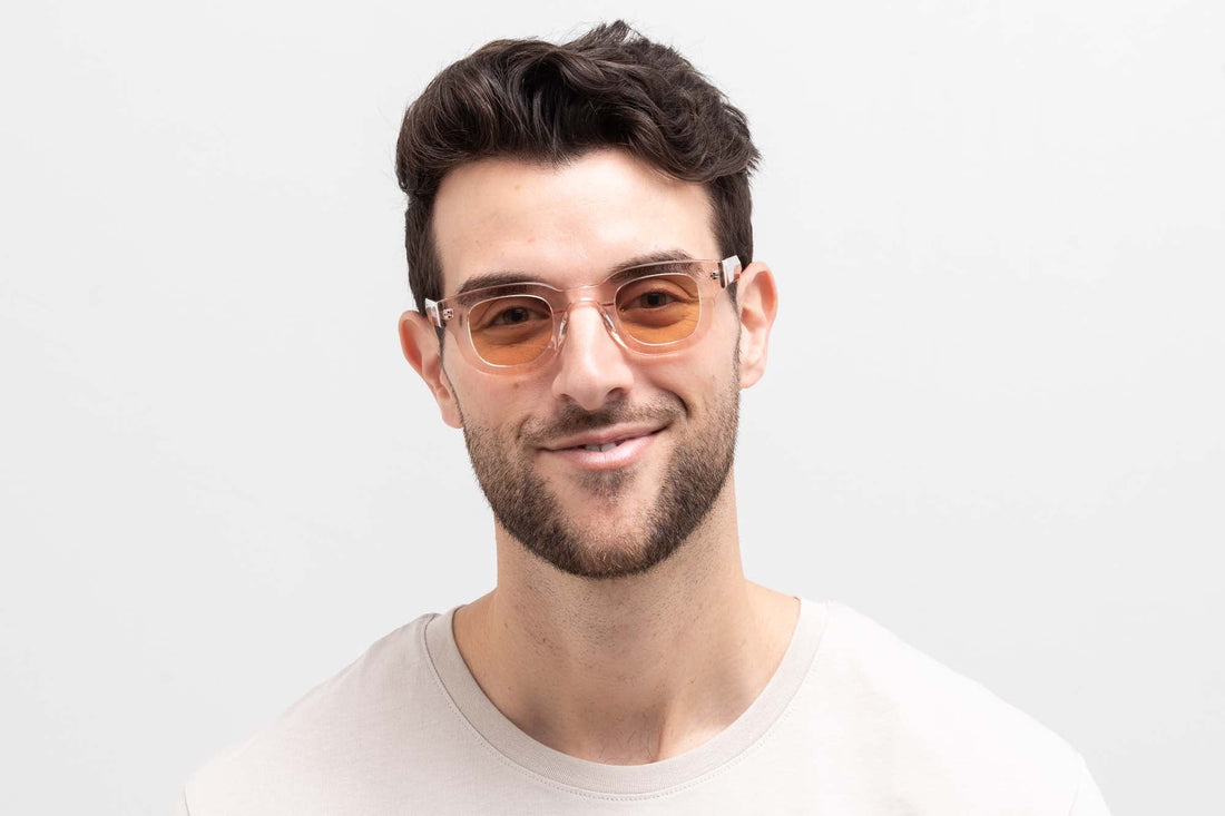 Homme portant des lunettes de soleil Juno Pink, des lunettes de soleil roses arrondies et épaisses avec des verres roses clairs