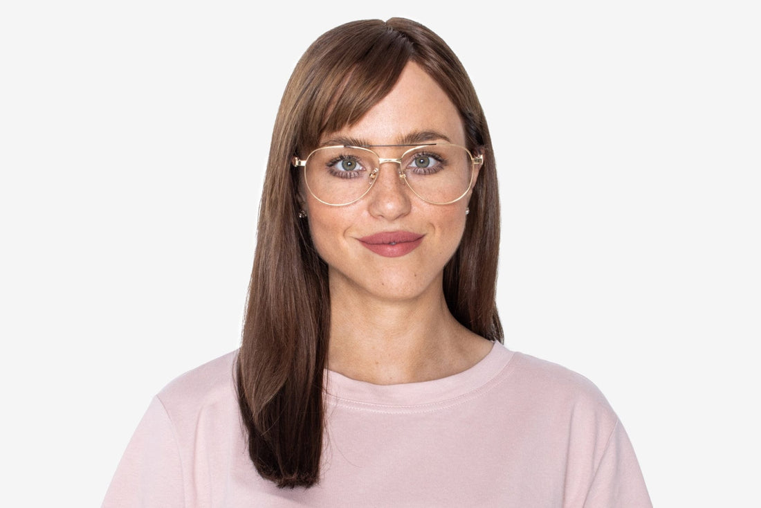 パーパス・ゴールドのオーバーサイズ・アビエーター・グラスをかけた女性