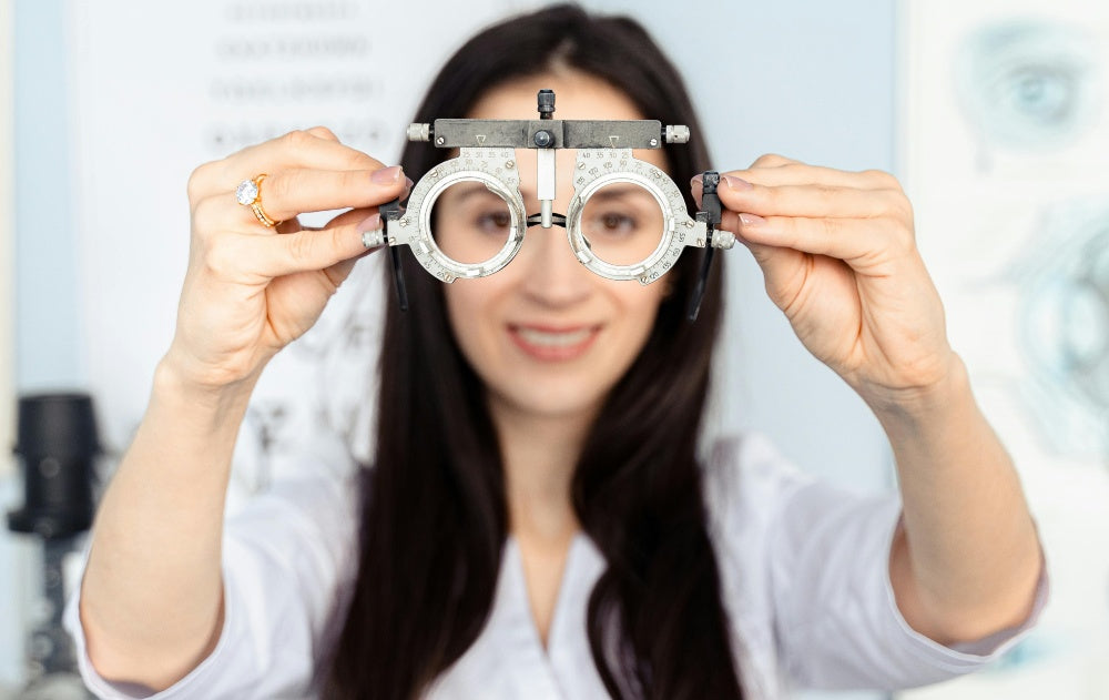 Optometrist håller i en provlinsram under en synundersökning